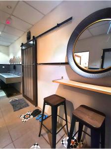 einen Waschtisch mit einem Spiegel und zwei Hockern in einem Zimmer in der Unterkunft Sleepbox Hotel in Cameron Highlands