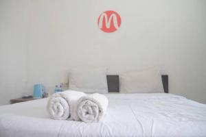 Una cama blanca con toallas encima. en Mugeni Homestay, en Senggigi 