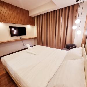 um quarto de hotel com uma cama e uma televisão em Eekos Hotels em Baguio