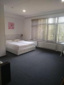 a bedroom with two beds and two large windows at Sakura Inn in Fergana