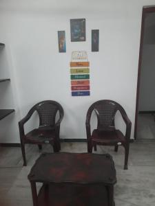 two chairs and a table with books on a wall at WHITE HOUSE- 1BK Pleasant Apartment with Open Terrace in Coimbatore