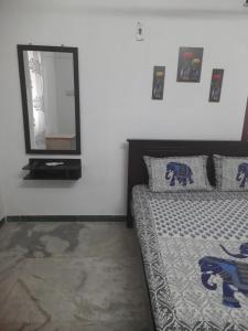 a bedroom with a bed and a mirror on the wall at WHITE HOUSE- 1BK Pleasant Apartment with Open Terrace in Coimbatore