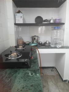 a kitchen with a stove top oven in a room at WHITE HOUSE- 1BK Pleasant Apartment with Open Terrace in Coimbatore