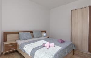 a bedroom with a bed with a pink bow on it at Cozy Apartment In Njivice With Kitchen in Njivice