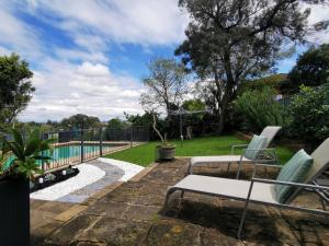 une terrasse avec 2 chaises longues et une piscine dans l'établissement Rare Find! 5-Bedroom Home with Pool and Pool Table, à Muswellbrook