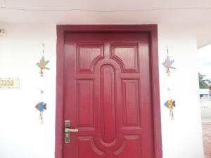a red door with two star decorations on a white wall at WHITE HOUSE- 1BK Pleasant Apartment with Open Terrace in Coimbatore
