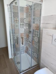 a shower with a glass door in a bathroom at Decò & Retrò apartment in La Spezia
