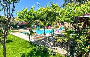 a backyard with a swimming pool and some trees at Amazing Home In Montlimar With Outdoor Swimming Pool in Montélimar
