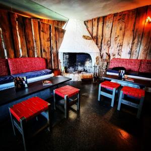 a restaurant with red seats and a fireplace at Hôtel Bel Angle in Les Angles