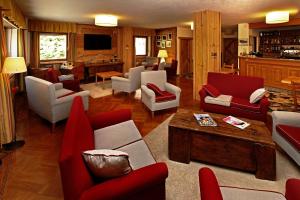 una sala de estar con muebles rojos y blancos y una sala de estar. en Hotel Biancaneve en Sauze dʼOulx