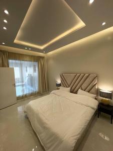 ein Schlafzimmer mit einem großen weißen Bett in einem Zimmer in der Unterkunft شاليه سفانه in As Sayl aş Şaghīr