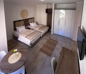 Boho Homes في الغردقة: غرفة نوم بسريرين وطاولة وتلفزيون