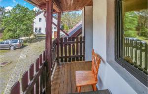 a wooden porch with a chair and a window at Beautiful Home In Legbad With 2 Bedrooms in Legbąd