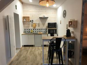 cocina con mesa y sillas en una habitación en Le Cottage du Vieux Moulin, en Ravilloles