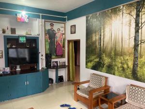 a living room with a large painting on the wall at Haobam House in Imphal