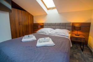 a bedroom with a bed with two towels on it at Farys - świetna lokalizacja, sauna, jacuzzi, piękne widoki z okien in Krynica Zdrój