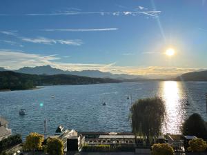 a view of a lake with the sun setting at Apartment Lake`s in Pörtschach am Wörthersee