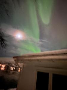 uma vista para a aurora a partir do telhado de uma casa em Håkøyveien 151, Tromsø em Tromsø