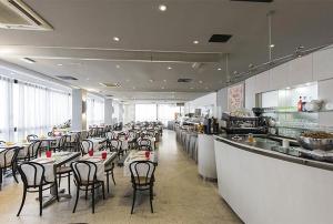 a restaurant with tables and chairs in a kitchen at Hotel Genty in Rimini