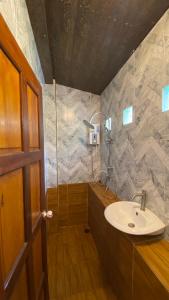 a bathroom with a sink and a shower at ภูคำฮ้อมคลิฟฟ์ลอดจ์ แอนด์ โฮมสเตย์ Phu come home cliff Lodge & Homestay in Ban Phu Hi