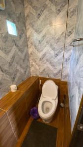 a small bathroom with a toilet in a stall at ภูคำฮ้อมคลิฟฟ์ลอดจ์ แอนด์ โฮมสเตย์ Phu come home cliff Lodge & Homestay in Ban Phu Hi