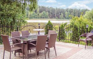 un patio con tavolo, sedie e una recinzione di Four-Bedroom Holiday Home In Sianow a Sianów