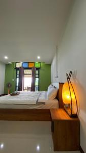 a bedroom with a bed with a lamp and a window at ภูคำฮ้อมคลิฟฟ์ลอดจ์ แอนด์ โฮมสเตย์ Phu come home cliff Lodge & Homestay in Ban Phu Hi