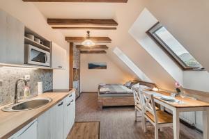 eine Küche mit einem Waschbecken und einem Tisch in einem Zimmer in der Unterkunft Privat LeNa in Ružomberok