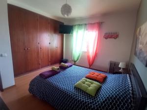 a bedroom with a bed with pillows on it at CASA DIAS in Vila do Bispo +1 photo