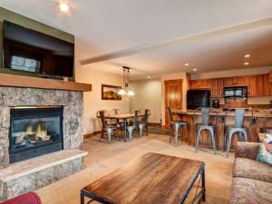 Una sala de estar con chimenea y una mesa y sillas. en Luxury 2 Bedroom Mountain Vacation Rental In Breckenridge With Access To A Hot Tub And Heated Garage Parking, en Breckenridge