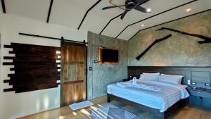 a bedroom with a bed and a ceiling fan at Rongna Villas in Ko Yao Noi