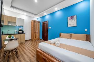 a bedroom with a large bed and a blue wall at Cozrum Homes - Retro House in Ho Chi Minh City