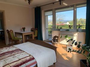 a bedroom with a bed and a balcony at chillout w Rychwaldzie in Żywiec