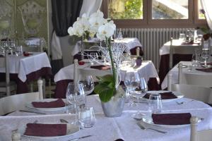 een tafel met witte borden en glazen en een vaas met witte bloemen bij Hotellerie de l'Esplanade in Rians