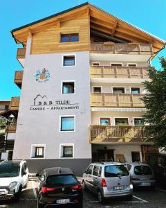 a building with cars parked in front of it at B&B Tilde in Tesero