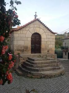 a small church with a wooden door and stairs at The Maggie Farm in Aranhas