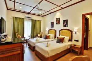 a hotel room with two beds and a piano at Backwater Ripples Kumarakom in Kumarakom