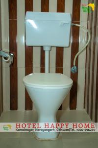 Hotel Happy Home في شيتوان: مرحاض أبيض مع علامة منزل سعيدة بجواره