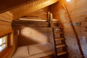 an attic room with two bunk beds and a ladder at Kuhglück Koralpe in Elsenbrunn