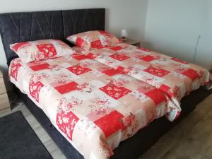 a bed with a red and white quilt on it at Mimi in Šibenik