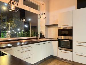 a kitchen with white cabinets and a black counter top at Apartment House Nová Dubnica in Nová Dubnica