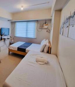 sypialnia z 2 łóżkami i oknem w obiekcie Nordic Bleu Staycation at Ayala Serin w mieście Tagaytay