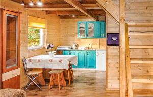 a kitchen with blue cabinets and a table and chairs at 2 Bedroom Pet Friendly Home In Karwienskie Blota in Karwieńskie Błoto Pierwsze