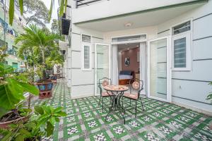a patio with a table and chairs on a house at Cozrum Homes - Retro House in Ho Chi Minh City