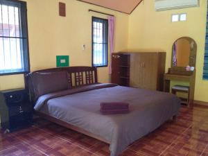 1 dormitorio con 1 cama grande en una habitación con ventanas en Sawai Home Resort en Nathon
