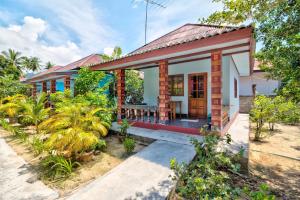 une petite maison avec un toit rouge dans l'établissement Sawai Home Resort, à Nathon