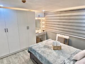 een slaapkamer met witte kasten, een bed en een wastafel bij IV’s Condo w/ Netflix, Wifi & Karaoke in Cainta