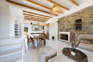 a living room with a stone wall and a table and chairs at Parian Philoxenia Villa, Santa Maria Beach in Kampos Paros