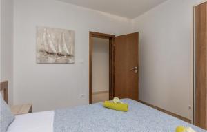 a bedroom with a bed with a yellow object on it at Amazing Apartment In Njivice With Kitchen in Njivice