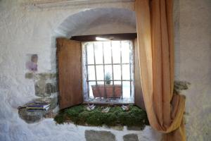 a window in a stone wall with a curtain at B&B A Casa Di Piero in San Massimo